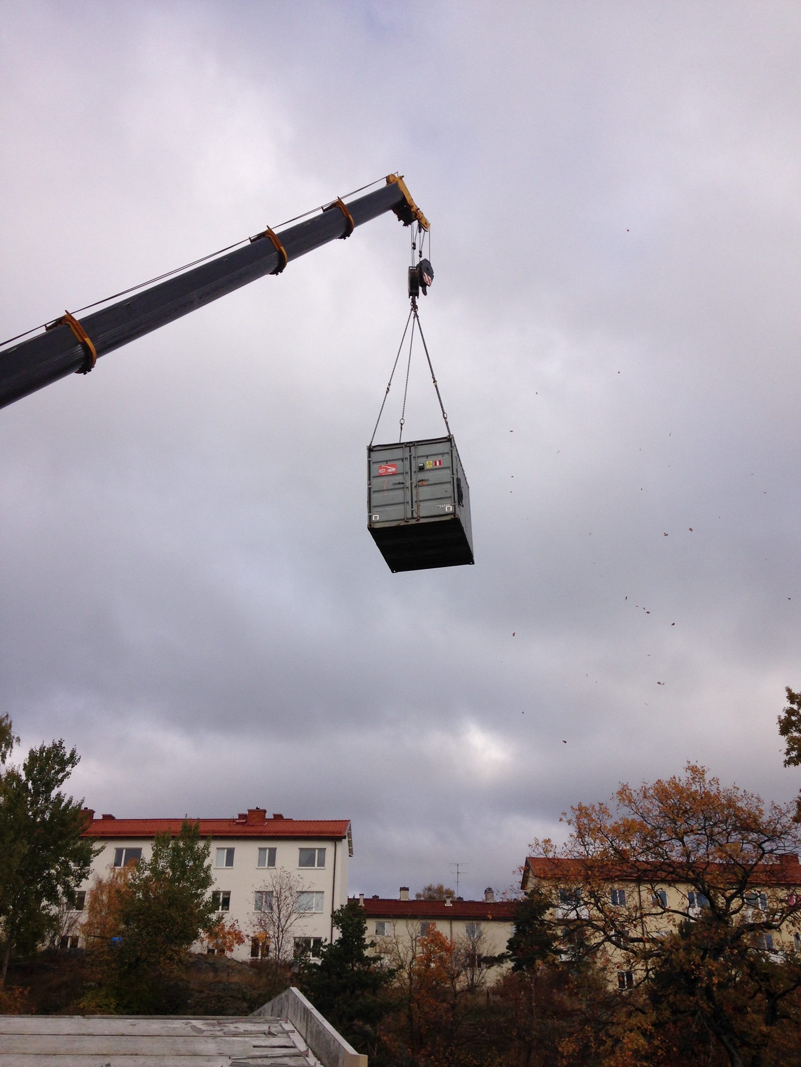 Grue mobile levant un conteneur maritime au-dessus d une zone residentielle