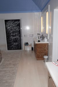 Meuble vasque en bois et douche dans une petite salle de bain, format compatible conteneur