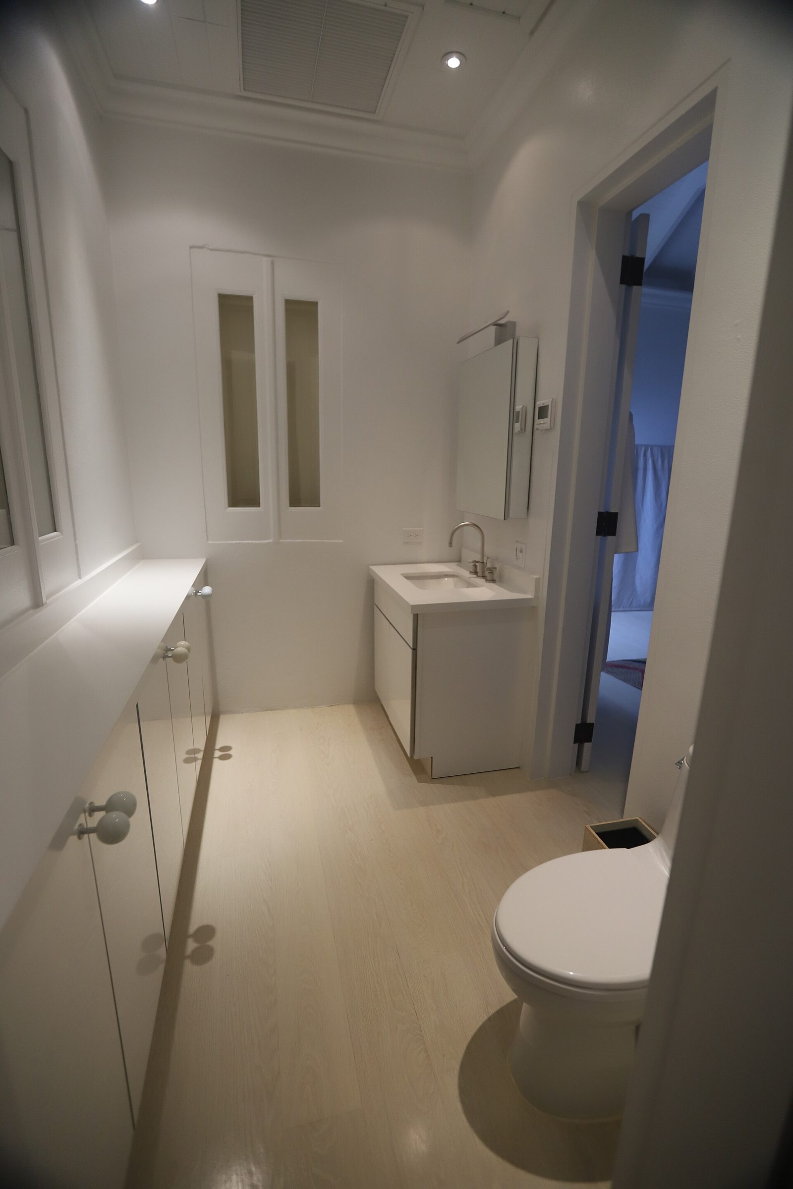 Meuble vasque compact et WC alignés sur un mur étroit, configuration type conteneur