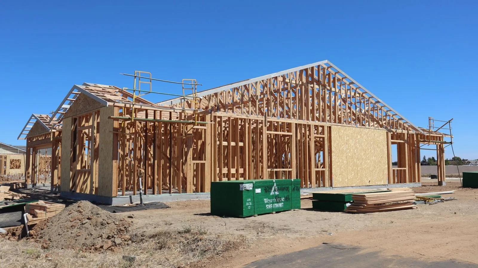 Ossature bois d'une maison en cours de construction sous un ciel dégagé