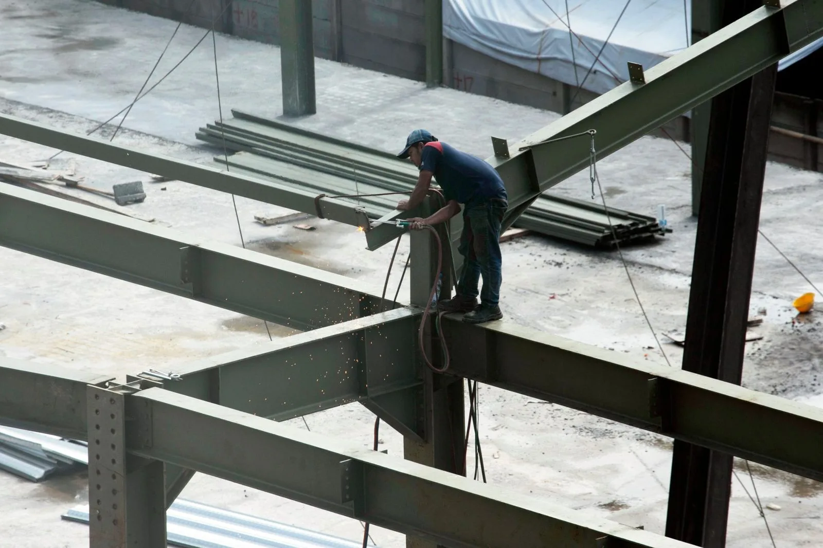 Soudeur assemblant des poutres en acier sur un chantier de construction